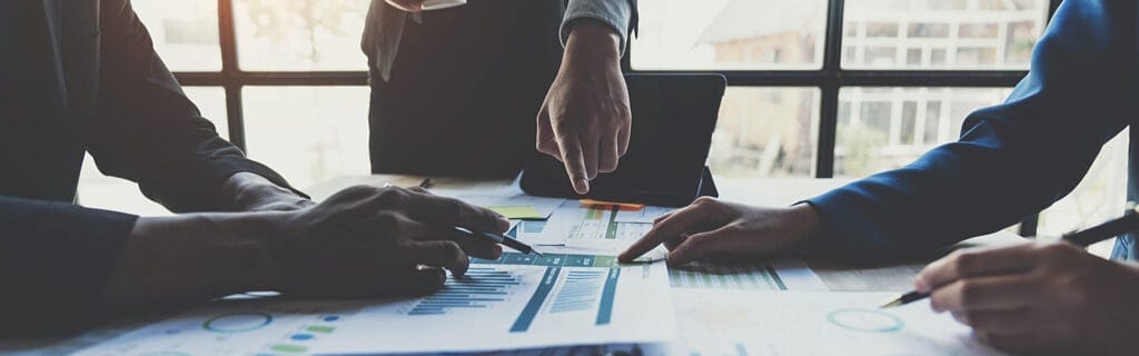 Business team analyzing charts and graphs during a meeting, discussing data and strategies for growth at a modern office.